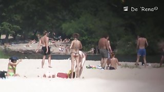 Beach nudist lying on the sand and showing his dick